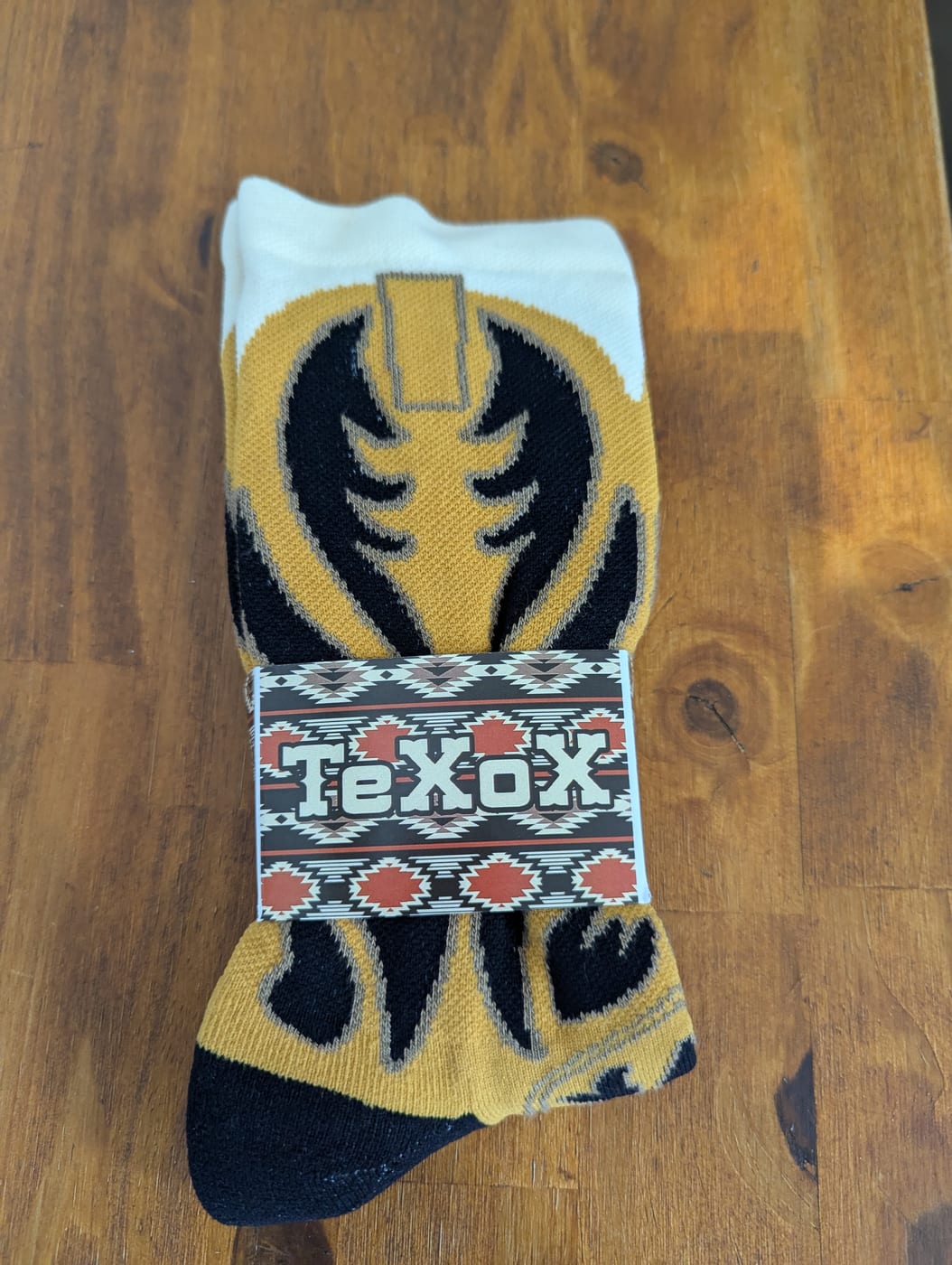 A folded pair of cowboy boot socks with the printed band wrapped around them, ready to give.