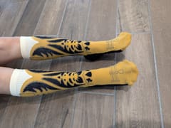 The socks worn, seen from above on a tiled floor.